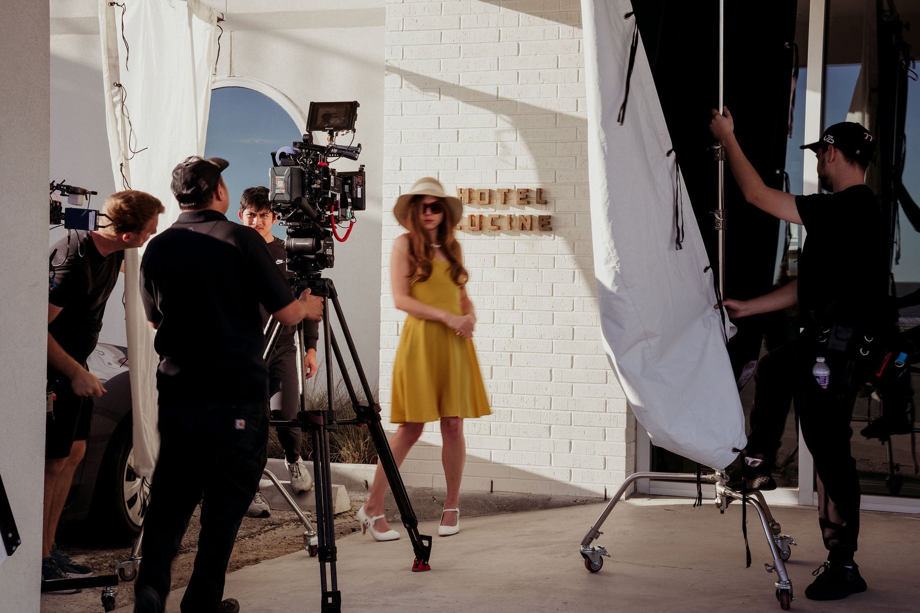Camera, lighting and crew working a scene on location